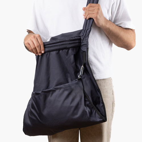 Persona llevando el Bolso Cosechador colgado al hombro, con las manos sobre la correa.